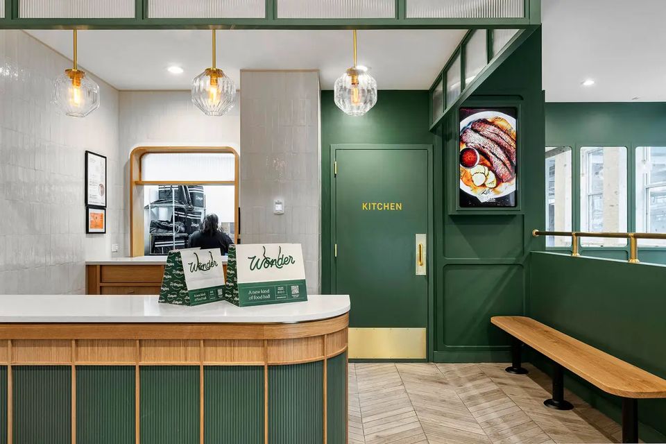 Green millwork service counter with brass pendants at a Wonder location